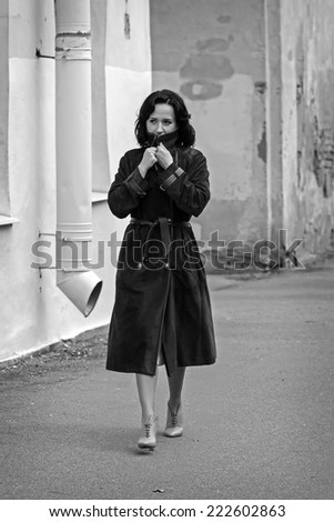 Young woman in coat walks in the city