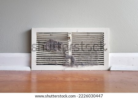 Dirty register wall vent with dust clogging the duct opening in a home  Royalty-Free Stock Photo #2226030447