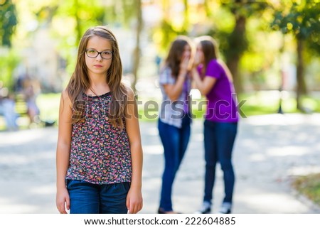 Envious girls discriminating her girlfriend by talking behind her Royalty-Free Stock Photo #222604885