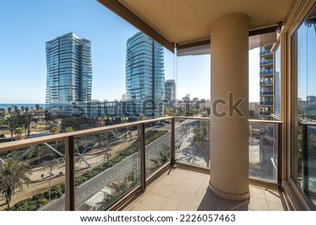 View from a balcony to modern buildings and sunny park in coastal area with sea view, distict Diagonal mar in Barcelona, Spain