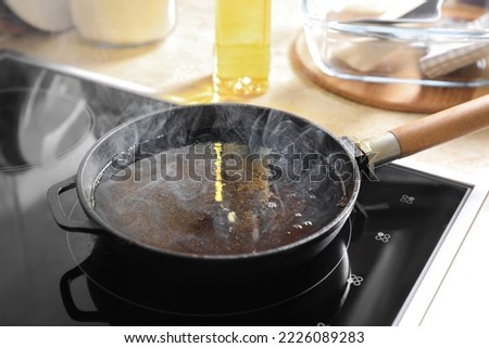 Frying pan with hot used cooking oil on stove Royalty-Free Stock Photo #2226089283
