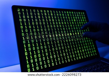 Ciber security concept. Gloved Hand, Binary code and cybersecurity word on laptop computer screen