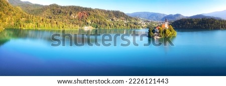 Panoramic view of Lake Bled in Slovenia. Aerial landscape photography. Colorful morning scene of Pilgrimage Church of the Assumption of Maria. Banner of famous like and popular travel destination.