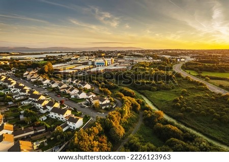 Aerial view on dense residential area with comfortable houses in a city suburb area. Galway town, Ireland. Cloudy sky. Growth and development concept. Property market and investment portfolio theme. Royalty-Free Stock Photo #2226123963