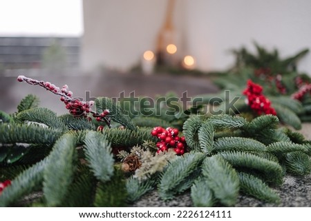 Macro photo of steaming cast iron hot tub with spa in winter with snow and decorated candles. Christmas twigs with guelder rose and pine cones