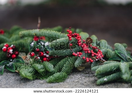 Macro photo of steaming cast iron hot tub with spa in winter with snow and decorated candles. Christmas twigs with guelder rose and pine cones