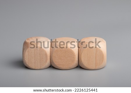 Empty wooden dice stacked on gray background