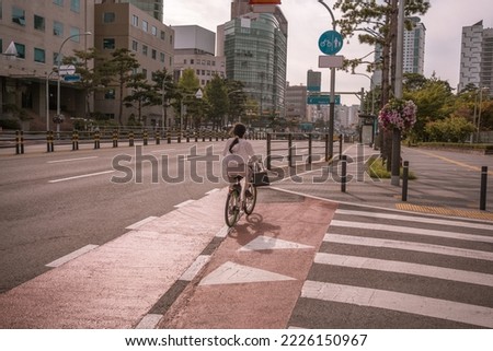 Girl cycling on bicycle lane street on Dongdaemun district in Seoul, South Korea.
