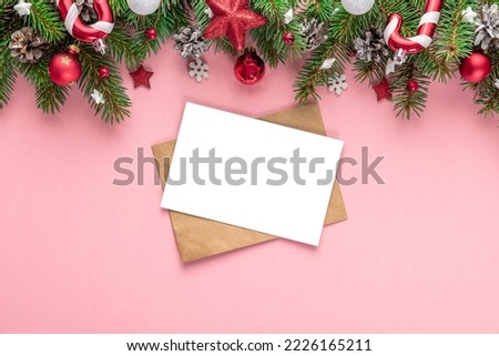 Christmas greeting card or festive invitation with fir tree, holiday decorations on pink background. Flat lay. Mock up. Top view with copy space. Festive background