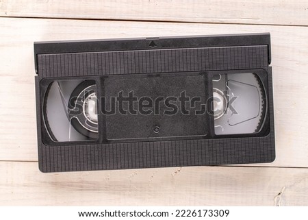 One video cassette on a wooden table, macro, top view.