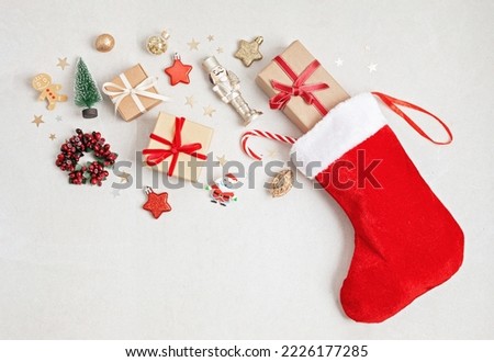 Red Christmas stocking with gifts and decoration. Traditional Xmas celebration concept Royalty-Free Stock Photo #2226177285