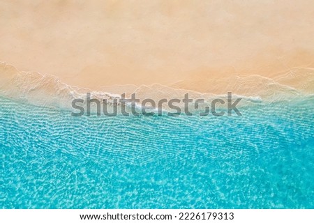 Summer seascape beautiful waves, blue sea water in sunny day. Top view from drone. Sea aerial view, amazing tropical nature background. Beautiful bright sea waves splashing and beach sand sunset light Royalty-Free Stock Photo #2226179313