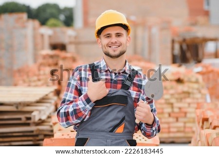 construction mason worker bricklayer installing red brick with trowel putty knife outdoors Royalty-Free Stock Photo #2226183445
