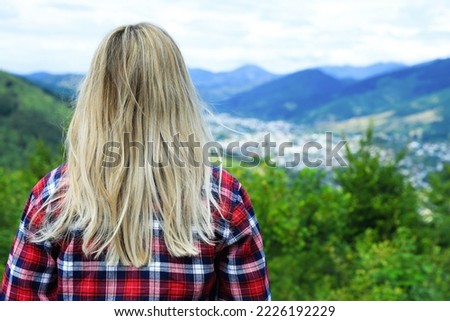 Woman enjoying beautiful mountain landscape, back view
