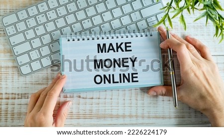 MAKE MONEY ONLINE text with decorative flower, calculator, fountain pen, keyboard and notepad on wooden background.