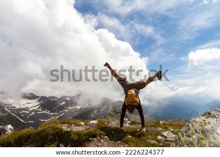 Handstand on top of a mountain in the Swiss Alps. Fit and happy man hiking in Switzerland Royalty-Free Stock Photo #2226224377
