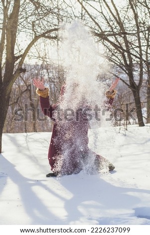 Lady throwing snow scenic photography. Wintertime activities. Picture of woman with winter forest on background. High quality wallpaper. Photo concept for ads, travel blog, magazine, article