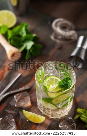 Mojito cocktail with lime and mint in glass on a grey background