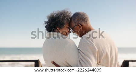 Sharing a romantic moment at the beach. Rearview of a happy senior couple touching their foreheads together on a seaside bridge. Retired elderly couple spending some quality time together. Royalty-Free Stock Photo #2226244095
