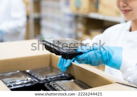 A woman packing food. Supply center of meals. Delivery food. Packaging factory.