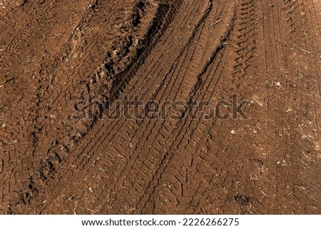 Tyre track on dirt sand or mud, Picture in retro or grunge tone. Car drive on sand. off road track. Track on grass field. Track in farm.