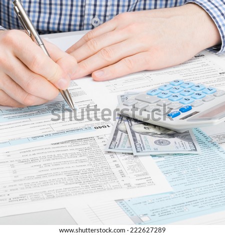 Man filling out 1040 US Tax Form - studio shot - 1 to 1 ratio