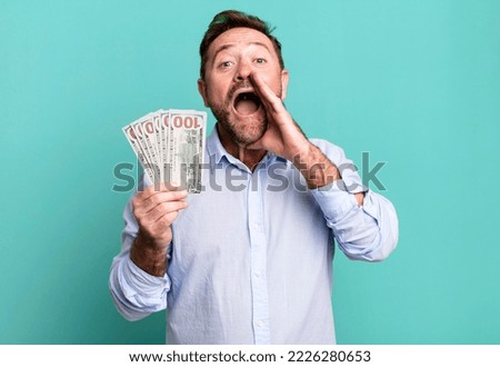 middle age man feeling happy,giving a big shout out with hands next to mouth. dollar banknotes concept
