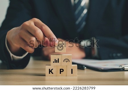 Key Performance Indicator (KPI). Businessmen arrange wood cubes with KPI icons. business goals, performance results, and indicators. For business planning and measuring success, target achievement. Royalty-Free Stock Photo #2226283799