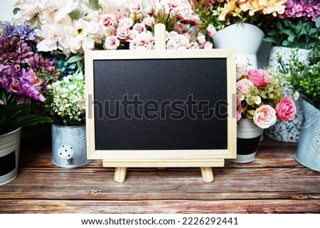 Empty easel chalkboard sign mockup with flowers decoration