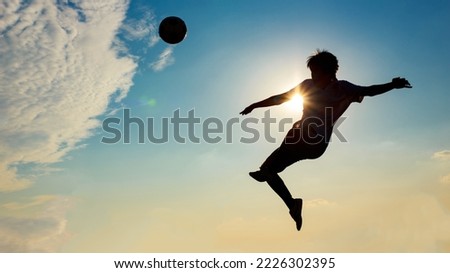 Silhouette action sport outdoors of football players on the sunset sky. Athlete man jumping kick soccer ball for world cup tournament background concept.