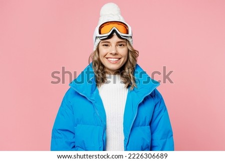 Snowboarder smiling happy woman 20s wear blue suit goggles mask hat ski padded jacket spend extreme weekend look camera isolated on plain pastel pink background. Winter sport hobby trip relax concept Royalty-Free Stock Photo #2226306689