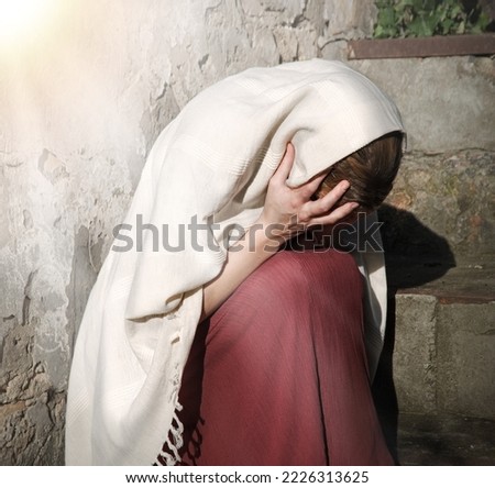 Misery lost feel mourn weep mood young lone holy jew maid slave teen lady Mary sit ask god Jesus Christ faith hope. Old retro roman history biblical adult human shame abuse white islam home text space Royalty-Free Stock Photo #2226313625