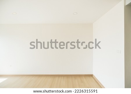 Empty room is decorated with an engineering wooden floor and wallpaper on the wall with sunlight from the window. Minimalist interior design and real estate for decoration. Real image with copy space.