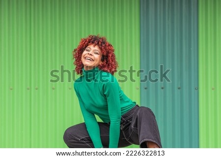 young woman in the street dancing outdoors on green background