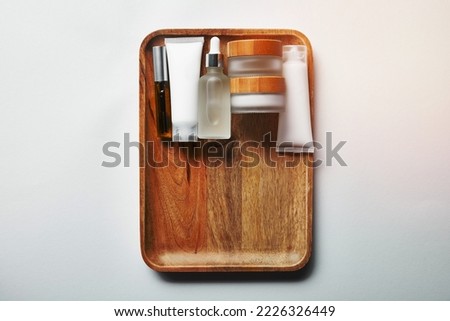 various cosmetic containers on wooden tray