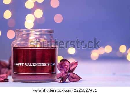 Burning candle on blurred background with bokeh, Valentine's Day concept.