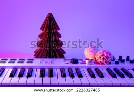 Christmas background with midi keyboard and holiday decor with neon lights.