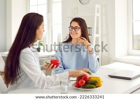 Dietitian helping woman lose weight. Nutritionist giving dieting consultation. Happy beautiful Caucasian girl listening to doctor recommending good dietary habits like natural food and balanced menu Royalty-Free Stock Photo #2226333241