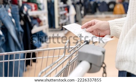 A smiling woman checking her shopping receipt isolated on white background Royalty-Free Stock Photo #2226337855