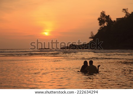 Silhouette of an unidentified couple enjoying in the beach during sunset