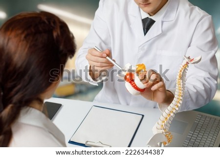 Orthopedic doctor consulting a patient in the office about vertebral hernia.