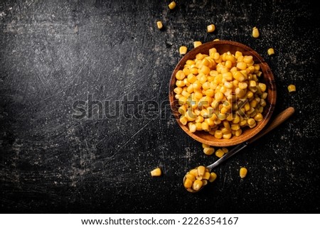 Canned corn on a wooden plate. On a black background. High quality photo Royalty-Free Stock Photo #2226354167