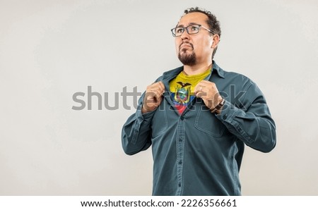 Fan man of 40s proud to show the jersey of the soccer team of his country Ecuador under his shirt, on white background