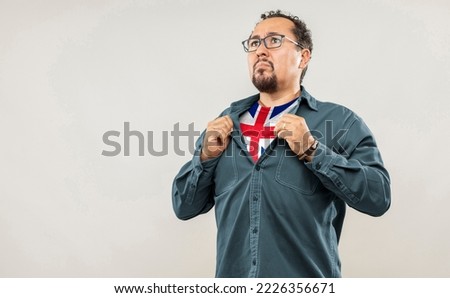 Fan man of 40s proud to show the jersey of the soccer team of his country England under his shirt, on white background