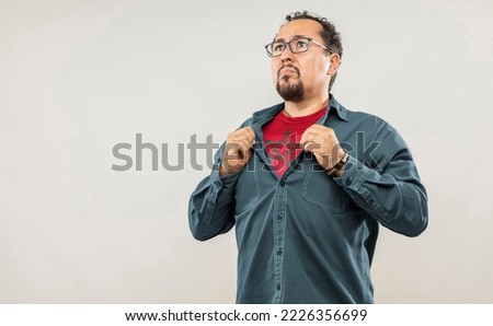 Fan man of 40s proud to show the jersey of the soccer team of his country Morocco under his shirt, on white background
