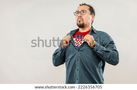 Fan man of 40s proud to show the jersey of the soccer team of his country Croatia under his shirt, on white background