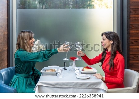 Girlfriends toasting with wine in the restaurant