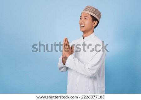Smiling Asian muslim man happy celebrating Eid Al-Fitr isolated white background. Celebrate Ramadhan Holy month in Islam