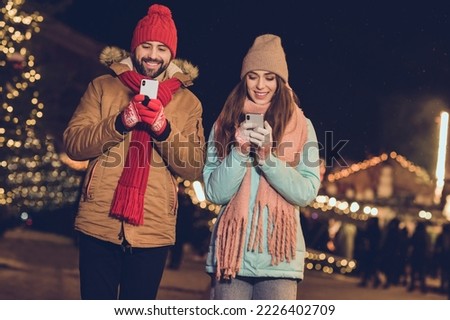 Photo of pretty charming girlfriend boyfriend typing greetings modern devices walking outdoors urban city market