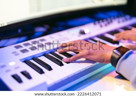 Producer, audio engineer uses a control panel and screen to record a track of a new album in a recording studio. Image producer, designer in working process
